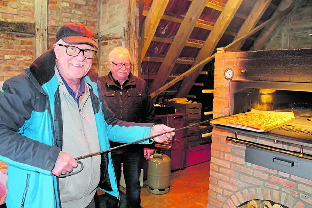 Manni Schurmann (li.) und Jo von Bargen holen den duftenden Butterkuchen aus dem Holzofen   Fotos: sb