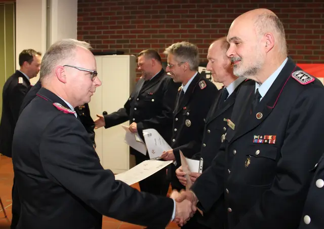 Gemeindebrandmeister Arnd König (li.) befördert seinen Bruder Ulf zum Ersten Hauptlöschmeister | Foto: Stefan Braun/FFW