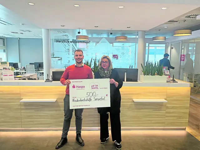 Haspa-Filialdirektor Marvin Rickmann übergibt den Spendenscheck an Anette Kosakowski, Vorsitzende der Hilfe für krebskranke Kinder Seevetal | Foto: Haspa