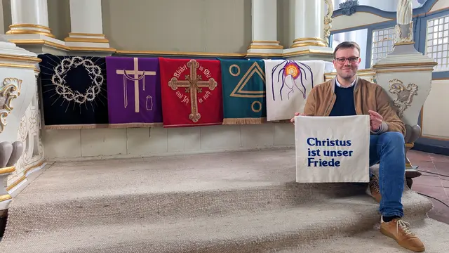 Pastor Jonas Milde präsentiert die traditionellen Antependien der St.-Nicolai-Kirche in Bützfleth | Foto: jd