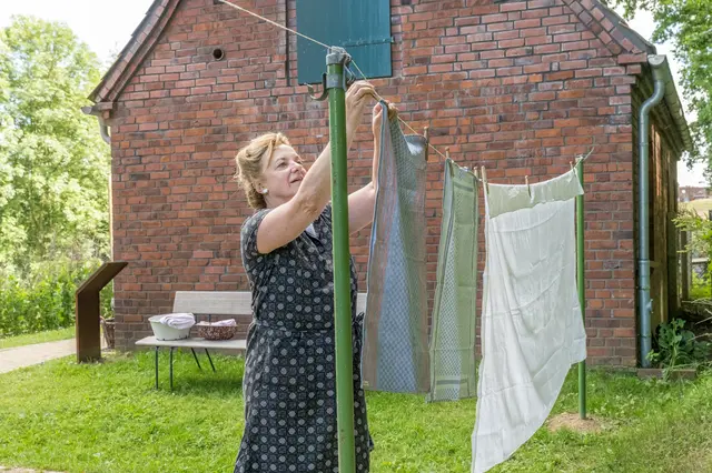 Hausfrau hängt Wäsche auf, Gelebte Geschichte 1964