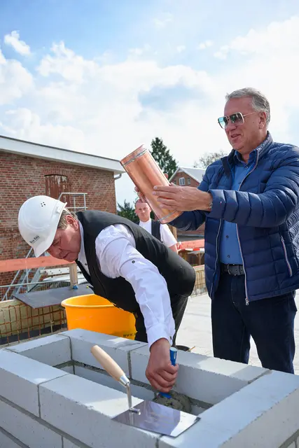 Jörg Schröder inspiziert die verschlossene Zeitkapsel, während Polier Jürgen Peters das Einbetonieren vorbereitet. | Foto: Schröder Immobilien