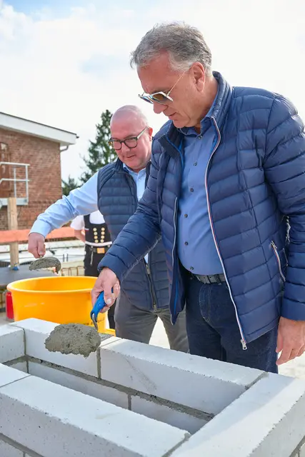 Jörg Schröder (rechts) legt Hand an und betoniert die Zeitkapsel zusammen mit David Erler, Geschäftsführer von BUX Bau ein. | Foto: Schröder Immobilien