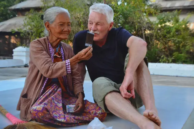 Eine  Frau in einem Tempel in Laos erklärt Isenberg ein Foto | Foto: Hermann Isenberg