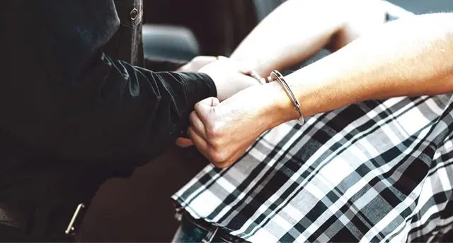 Polizist legt Handschellen an (Symbolbild) | Foto: KI