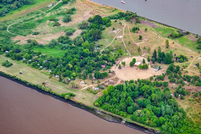 Der Bereich zum Fahrwasser hin bleibt überwiegend den Dauercampern vorbehalten (untere linke Bildhälfte). Deren Stellplätze befinden sich wie an einer Kette aufgereiht an einem kleinen Hang | Foto: Martin Elsen/nord-luftbilder.de