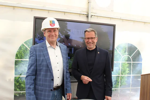 Kai Seefried überreicht Ralf Burghartz zum Baustart einen Bauhelm mit Landkreis-Logo | Foto: sb