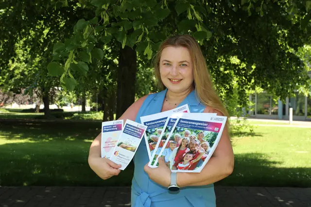 Isabella Kruppa präsentiert den neuen Seniorenwegweiser sowie die weiteren Infobroschüren zur Ehrenamtlichen Wohnberatung und zum Senioren- und PflegeStützpunkt | Foto: LK Harburg