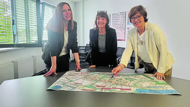 Projektleiterin Melanie Mierau, Wirtschaftsförderin Kerstin Maack sowie Bürgermeisterin Katja Oldenburg-Schmidt vor dem Plan Alter Postweg