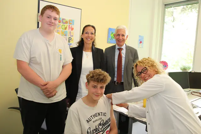 Dörthe Erdmann (re.) impft den 14-jährige Maximilian im Beisein seines Bruders Bastian (v. li.), Kreisrätin Ana Cristina Bröcking und Landrat Rainer Rempe | Foto: Landkreis Harburg