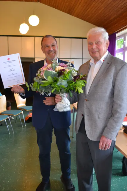 DRK-Kreisgeschäftsführer Thomas Grambow (li.) würdigte die Verdienste von Dieter Weis mit einem Blumenstrauß und einer Urkunde | Foto: bim