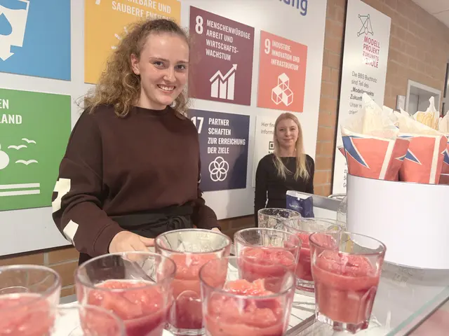 Zwei Schülerinnen mit Erdbeerdrinks und Popcorn im Foyer der Aula  | Foto: Silke König