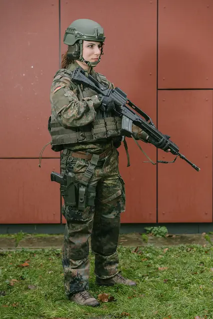 Eine Soldatin in ihrer vollständigen Gefechtsuniform mit Waffe und Munition. Sie wirkt beinahe wie eine Figur in einem Computerspiel. | Foto: Teresa Halbreiter