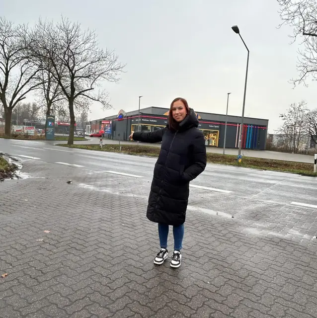 Eine engagierte Bürgerin, Angelina Rodrigo, zeigt die Stelle, an der nach ihren Beobachtungen die Straße insbesondere von alten Menschen oft überquert wird, um zu den Versorgermärkten zu kommen | Foto: Luna Tonn