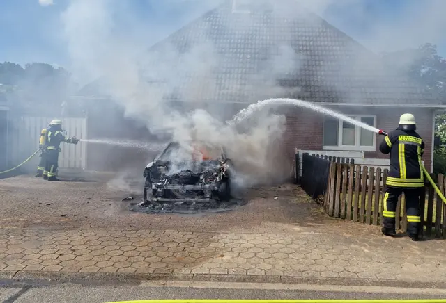 Die Feuerwehrleute beim Löschen des an einem Wohnhaus stehenden Opel | Foto: Mathias Wille