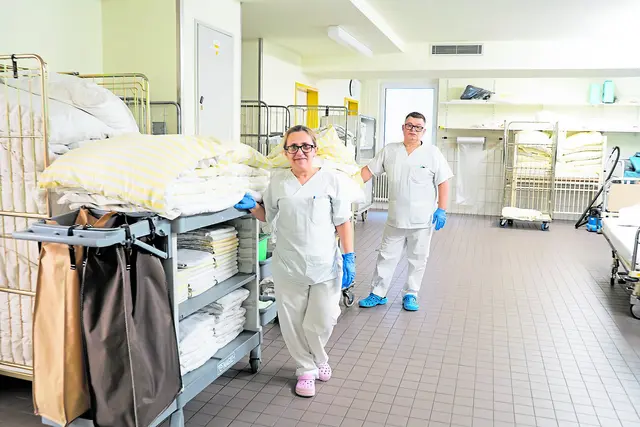 Elena Stefanovska (li.) und Carlos Vargas aus dem Team Bettenaufbereitung machen sich auf den Weg zu ihren Stationen am Elbe Klinikum Buxtehude, wo sie die Betten mit neuer Wäsche versehen | Foto: Elbe Kliniken / Kati Meyer-Thiedig