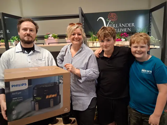Auszubildender Aaron Knaack (v. li.) übergibt den Airfryer an die glücklichen Gewinnerfamilie Anika Szepanski und Kinder | Foto: Famila Warenhaus Jesteburg