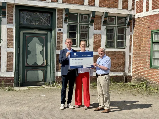 Freude über die Förderung: Jan Thesing (v.li.) und Inga Thesing nehmen den symbolischen Fördermittel-Scheck über 75.000 Euro für die denkmalgerechte Sanierung ihres Gebäudes von Dr. Reinhard Kolk entgegen | Foto: sts