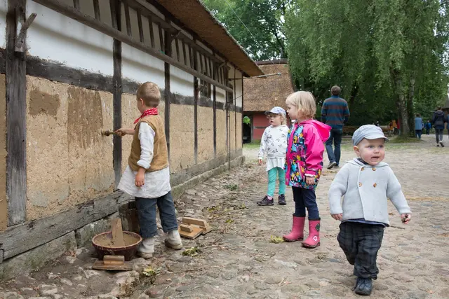 Die „Gelebte Geschichte“ geht vom 21. bis 26. Juli den Hofarbeiten wie Lehmputz nach, Kinder befüllen ein kleines Fachwerkhaus mit Lehm. | Foto: FLMK