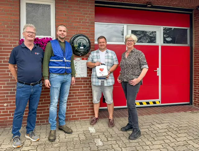 Von links: Andreas Klask (DRK-Kreisverband Harburg-Land e.V.), Marcel Lindackers (Mobiler Retter und Feuerwehr Seevetal), Torben Otte (Mobiler Retter und Ortsbrandmeister FFW Meckelfeld), Bürgermeisterin Emily Weede mit Defibrillator am Feuerwehrgerätehaus Glüsingen | Foto: Gemeinde Seevetal