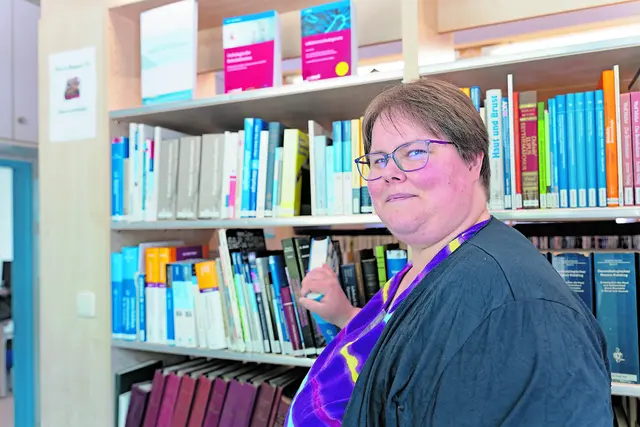 Silvia Faber holt in der Zentralbibliothek am Elbe Klinikum Buxtehude ein medizinisches Fachbuch aus dem Regal | Foto: Elbe Kliniken / Kati Meyer-Thiedig