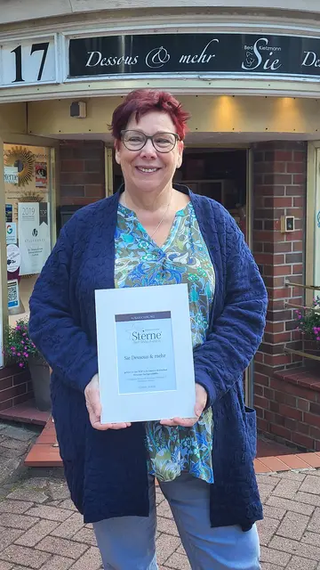 Beatrice Kietzmann mit der Urkunde vor ihrem Geschäft in Buxtehude