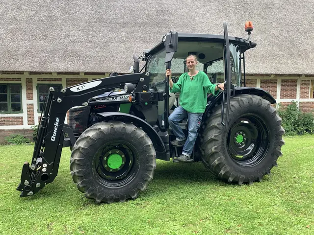Blonde Frau in grünem Oberteil an einem modernen Traktor