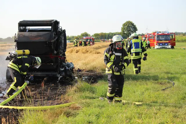 Feuerwehrleute mit Atemschutzgeräten löschten die Ballenpresse ab | Foto: Rolf Hillyer-Funke/Feuerwehren SG Oldendorf-Himmelpforten