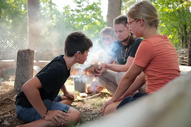 Ein Teilnehmer des Sommercamps pustet vorsichtig ins Glutnest, das ohne moderne Hilfsmittel zum Glimmen gebracht wurde | Foto: Alexander Meyer
