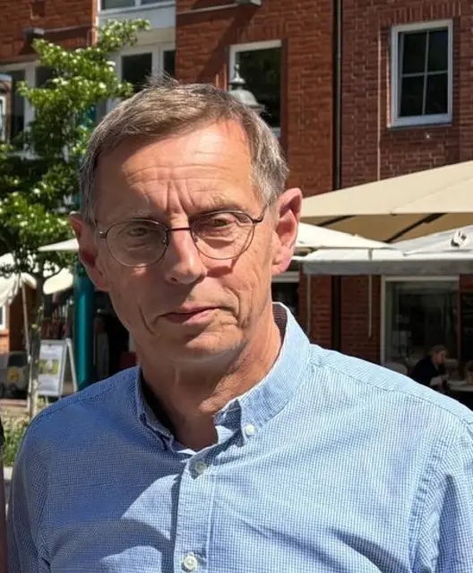 Ulrich Wiegel, Vorsitzender des Buxtehuder Altstadtvereins, begrüßt den Start des Profirennens in Buxtehude | Foto: pau