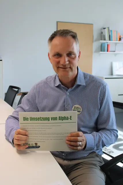 Salzhausens Samtgemeinde-Bürgermeister Jens Köster wirbt mit Infomaterial und Button für die Realisierung des Alpha-E-Konzeptes  | Foto: ce