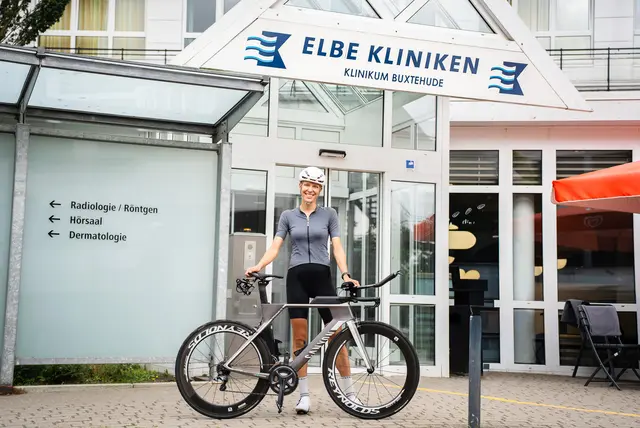 In voller Montur: Louisa Pranger im Trainingsoutfit und mit ihrem Rennrad vor dem Elbe Klinikum Buxtehude | Foto: Elbe Kliniken, Sebastian Braeutigam