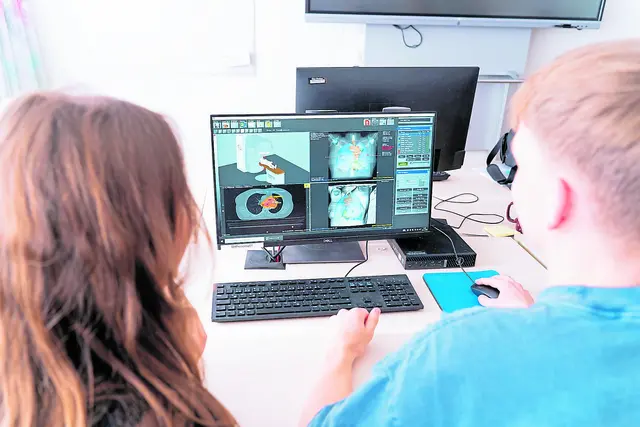 Sarah Barczewski (li.) und Justin Sladek besprechen eine Strahlentherapieplanung eines Krebspatienten | Foto: Elbe Kliniken/Kati Meyer-Thiedig