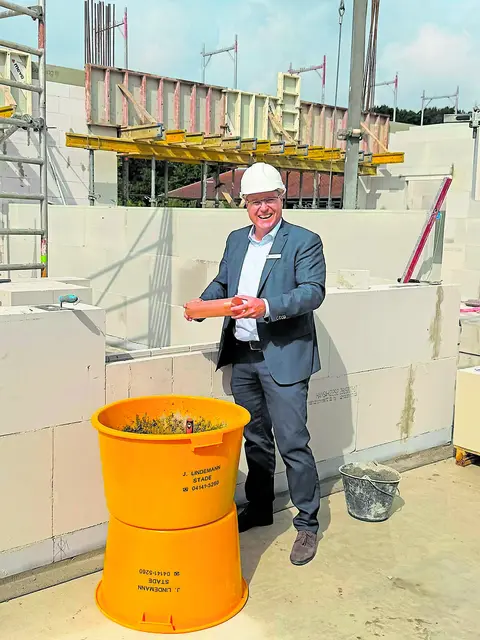 Matthias Hartlef mit der Zeitkapsel. Nach dem Einmauern wurde der Betonstreifen mit Datum versehen | Foto: Samtgemeinde Fredenbeck