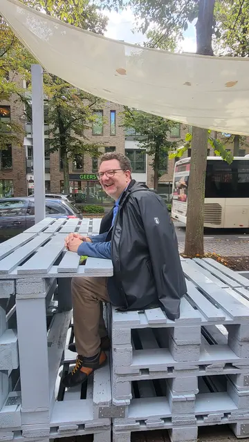 Prof. Karsten Ley am Arbeitsplatz im Freien, der in die Sitzgruppe vor dem Fidelio integriert ist