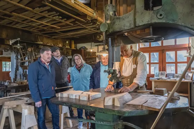 In der Museumsstellmacherei in Langenrehm schauen Besucher ehrenamtlichen Stellmachern bei der Arbeit an rund 100 Jahre alten Maschinen zu.