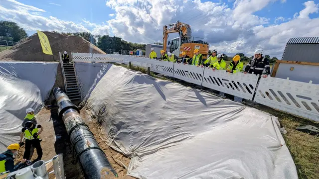 Die Besucher schauen sich die Baugrube mit der Erdgasleitung an. Durch das Rohr soll später Wasserstoff strömen | Foto: jd