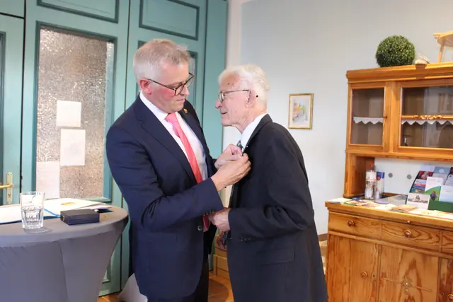 Knut Willenbockel steckt Dr. Peter Brümmel die Ehrennadel an | Foto: sb