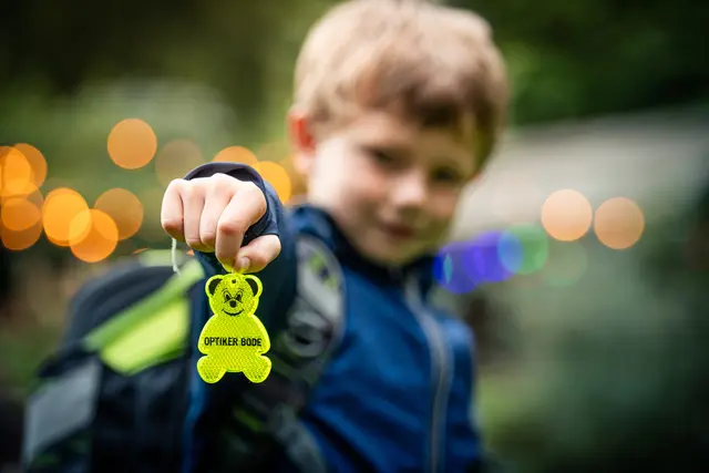 Ein Schulkind zeigt einen Blinkie-Bär