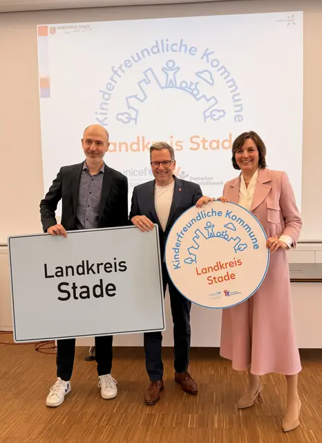 Landrat Kai Seefried freut sich mit Dominik Bär, Geschäftsführer des Vereins Kinderfreundliche Kommunen, und der Parlamentarischen Staatssekretärin Mareike Wulf aus dem Bundesfamilienministerium über die Auszeichnung | Foto: Landkreis Stade / Daniel Beneke