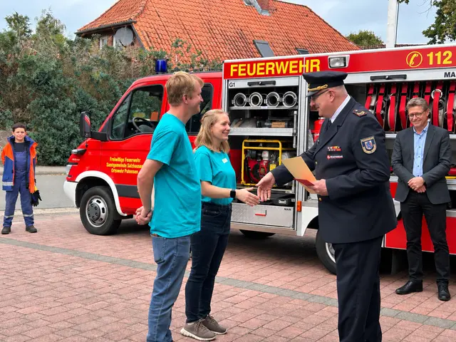Stellv. Abschnittsleiter André Emme gratuliert Kinderfeuerwehrwartin Josephine Klimek und Stellvertreter Ole Appel. Hinten rechts: Salzhausens Ordnungsamtsleiter Falk Pillath | Foto: Feuerwehr Putensen / Mit KI Bearbeitet