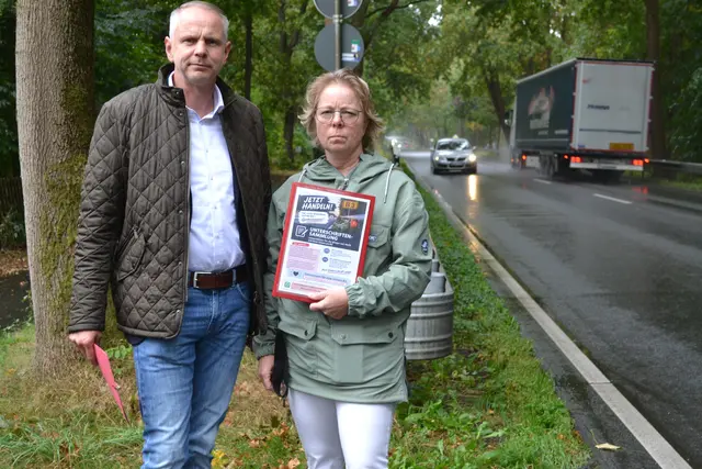 Welles designierter Bürgermeister Sven Behr und Anwohnerin Michaela Bachorz an der B3 in Höhe des Sportplatzes mit dem Logo der Petition. Das Ortsausgangsschild liegt noch geschätzte 100 Meter weiter hinter dem Lkw | Foto: bim