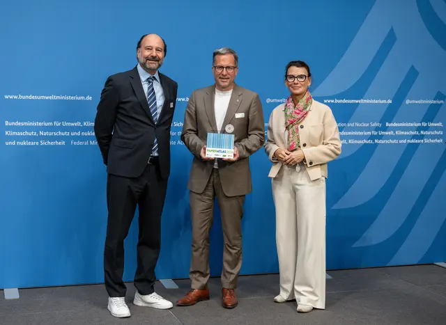 Kai Seefried (Mitte) nahm den Preis von Marc Gebauer (Sprecher der Initiative Pro Recyclingpapier, links) und der Parlamentarischen Staatssekretärin Rita Schwarzelühr-Sutter (rechts) entgegen | Foto:  IPR/Mark Bollhorst