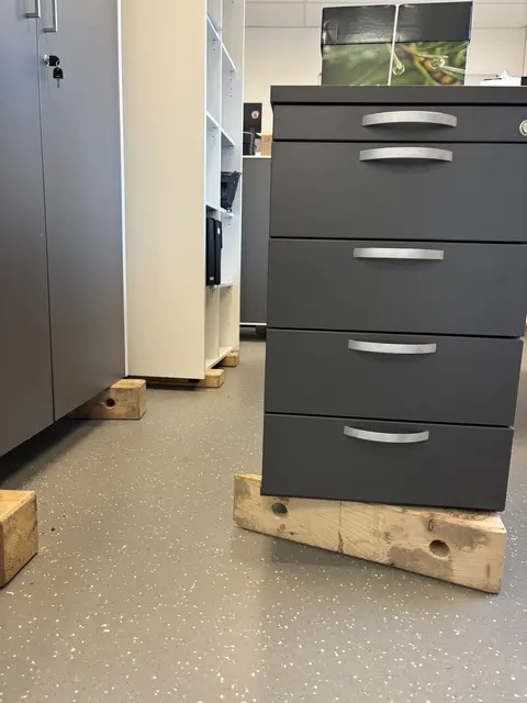 Im Büro stehen Schränke auf Holzblöcken damit sie nicht auf dem feuchten Boden stehen müssen