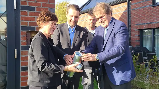 Katja Oldenburg-Schmidt, Dirk und Andreas Viebrock (re.) befüllen die Zeitkapsel.  André Dittmer, (2. v. re.) Maurer und Kolonnenführer bei Viebrockhaus, wartet auf seinen Einsatz, die Kapsel einzumauern