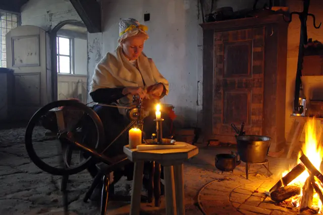 Bei „Feuer und Licht. Beleuchtung durch die Jahrhunderte“ am 8.11. spinnt eine Darstellerin der "Gelebten Geschichte" im Freilichtmuseum am Kiekeberg wie 1804 am Kerzenlicht und offenen Feuer. | Foto: FLMK