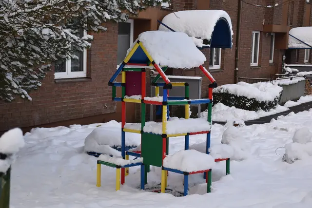 Ein verschneites Klettergerüst. Die Kinder bauen gerade einen Schneemann | Foto: Axel-Holger Haase